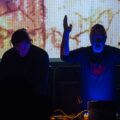 Ur.X live in New York: Uri Killisch mit erhobenen Armen, Enkidu rankX am Rig, davor die Projektionswand — Foto (c) Sulamith Sallmann